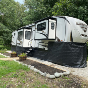 Fifth Wheel with RV skirting parked at campsite