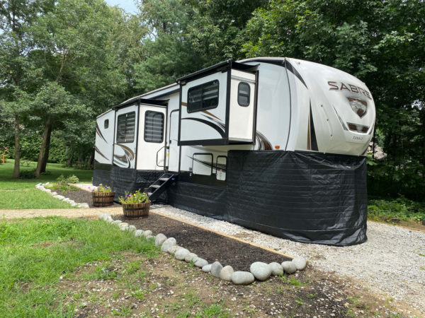 Fifth Wheel with RV skirting parked at campsite