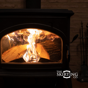 Wood is burning inside a wood stove. The light being emitted by the fire calms the darkness and glows brightly.