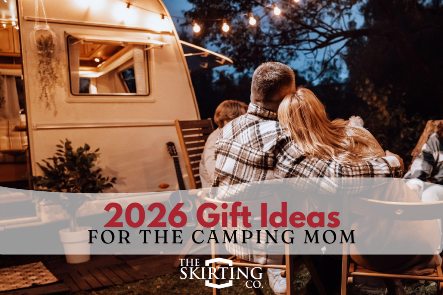 A mom and dad sit outside near their camper.